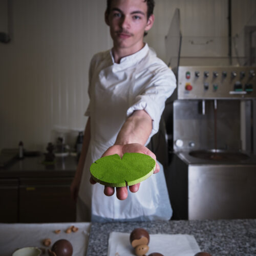 Apprenti chocolatier tenant un galette de pistache - Chocolatier Joseph Périgueux