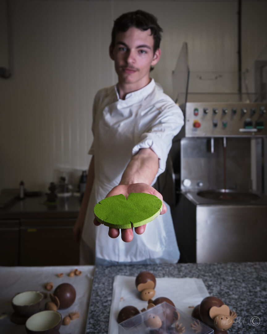 Apprenti chocolatier tenant un galette de pistache - Chocolatier Joseph Périgueux