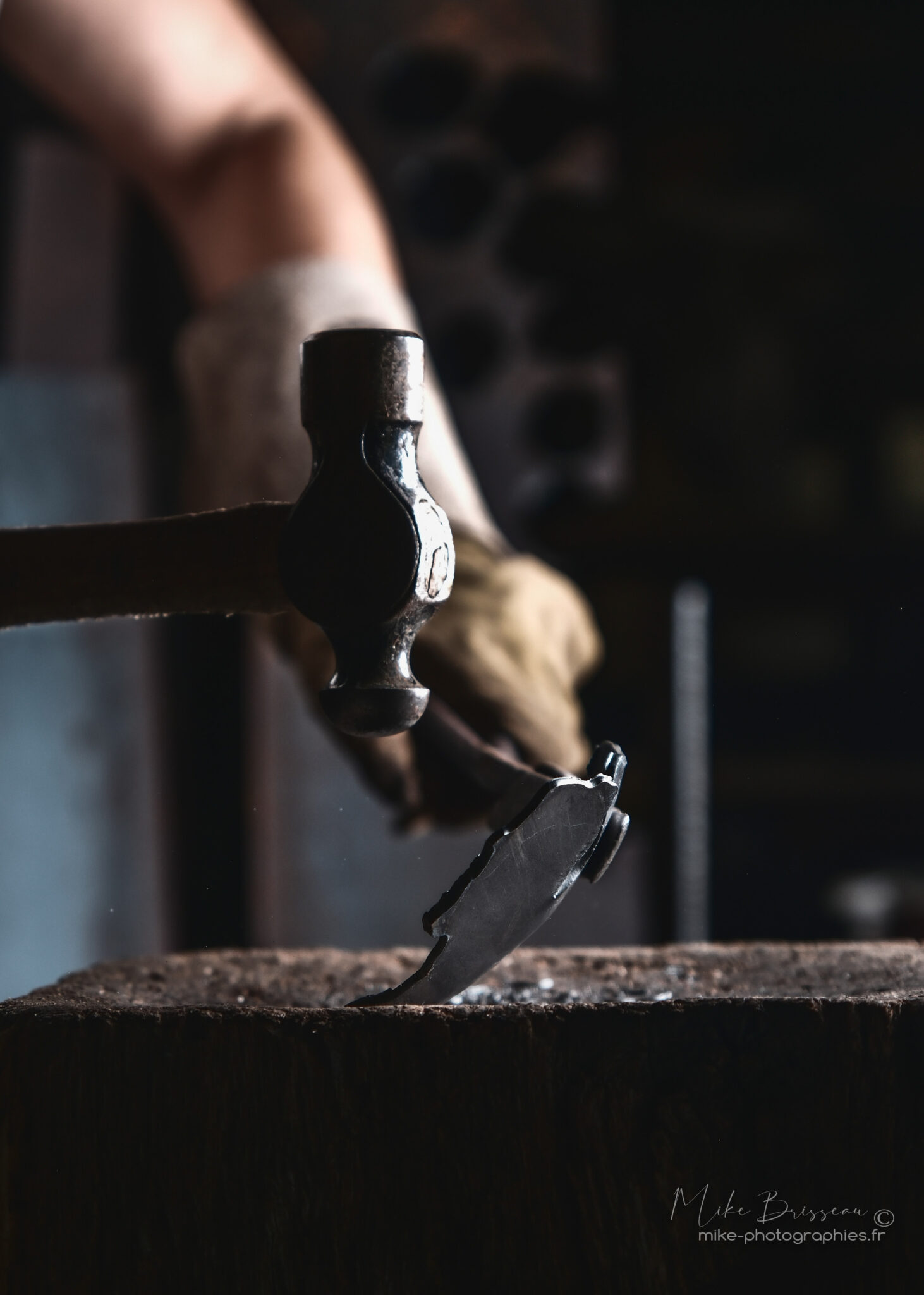 Sculpteur métal au marteau en plein geste technique - artisan d'art Dordogne